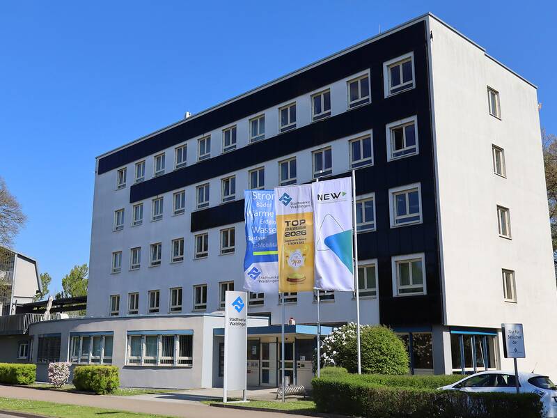 Das Hauptgebäuder der Stadtwerke Waiblingen mit wehenden Flaggen vor dem Eingangsbereich
